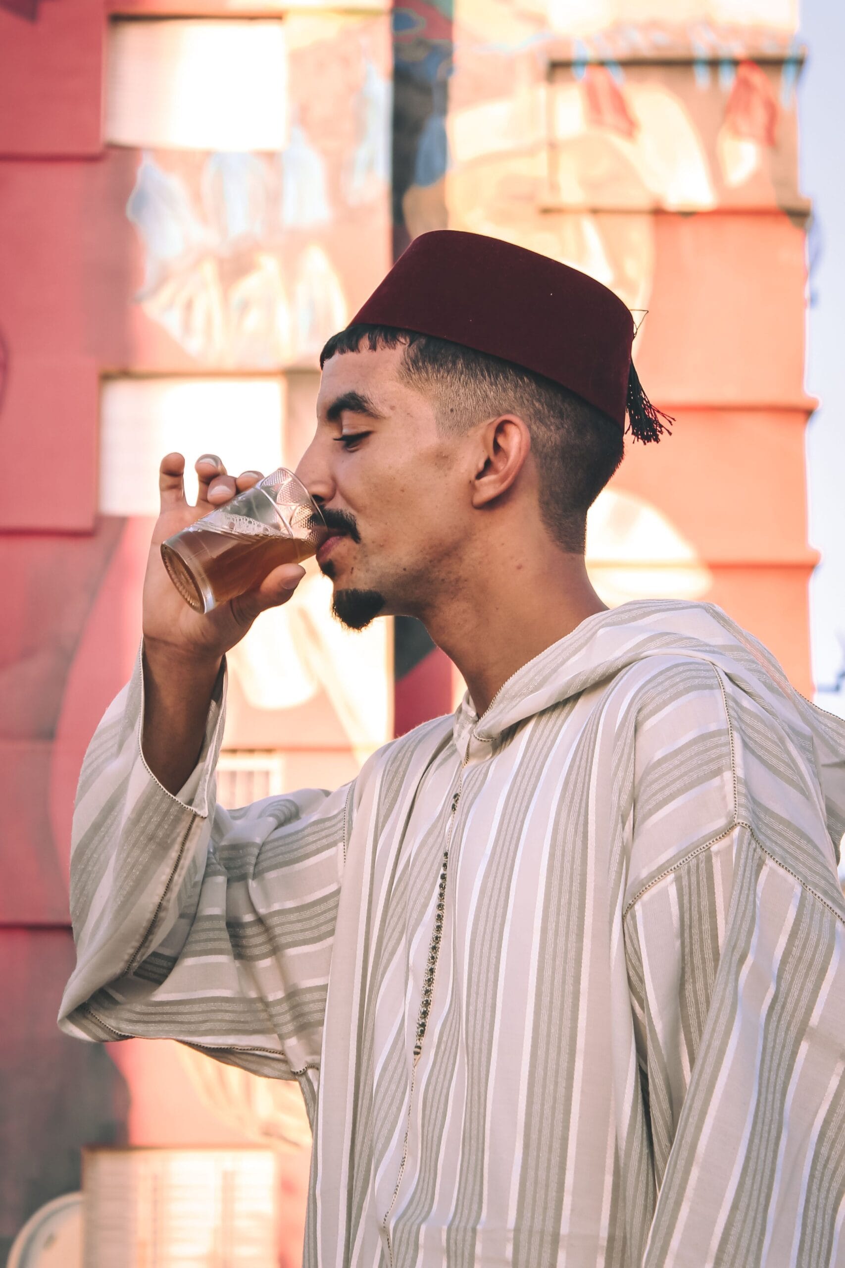 A man in traditional dress enjoying Moroccan mint tea in Fez