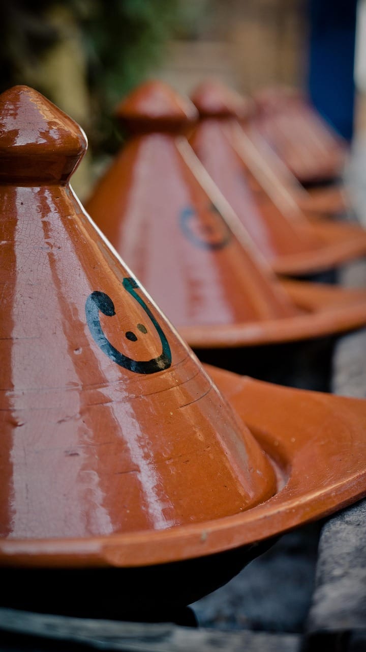 Hand-painted Moroccan tagine cookware in traditional conical clay pots